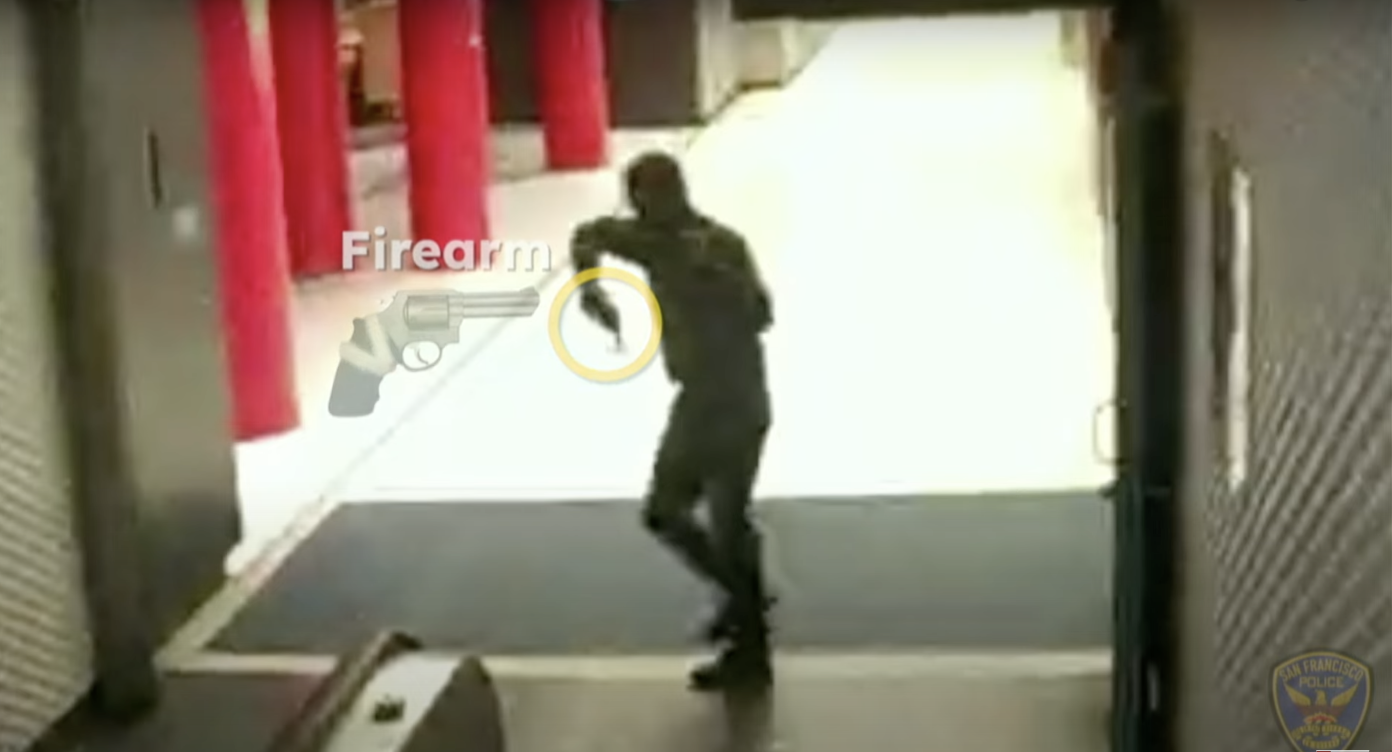 A person is walking indoors while holding a firearm. Location appears commercial, with red pillars and an escalator visible. An on-screen label highlights the firearm.